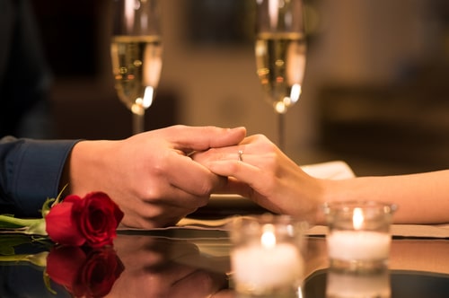 Couple holding hands during romantic dinner